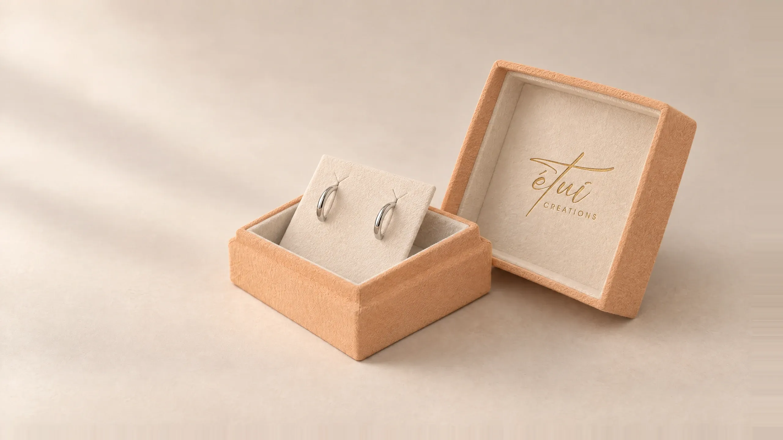Open box in Caramel / Cream: lid beside the base, hoop earrings in the insert