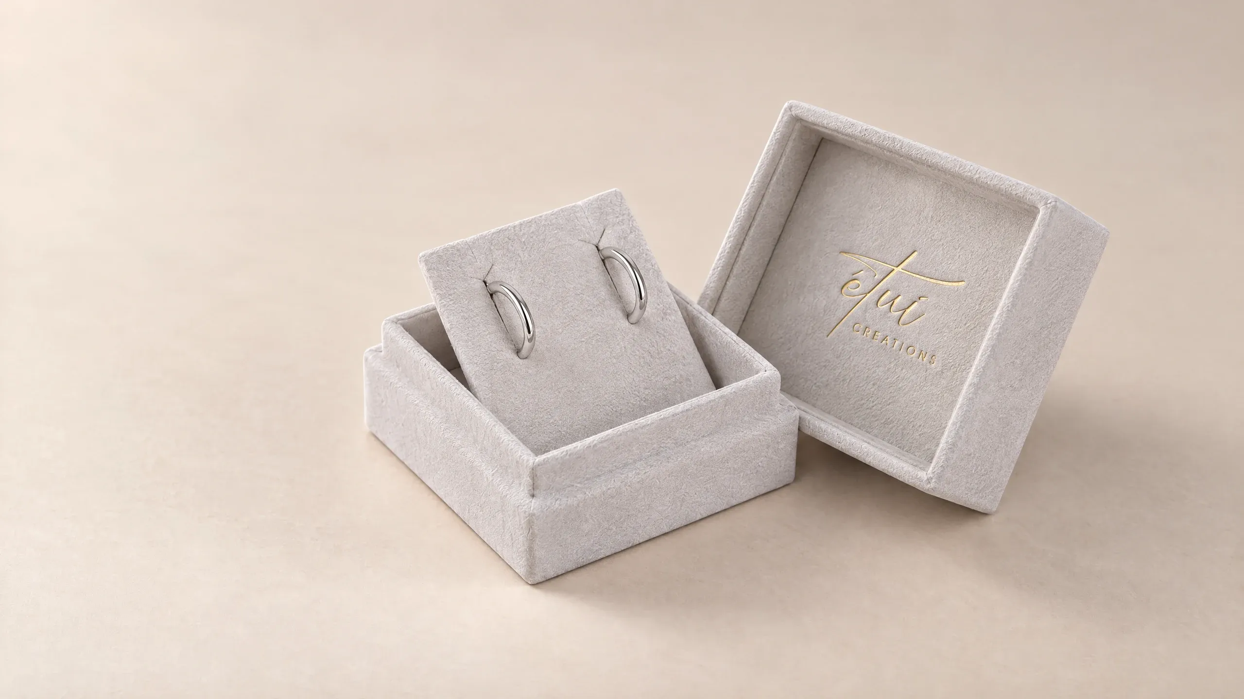 Open box in Grey: lid beside the base, hoop earrings in the insert