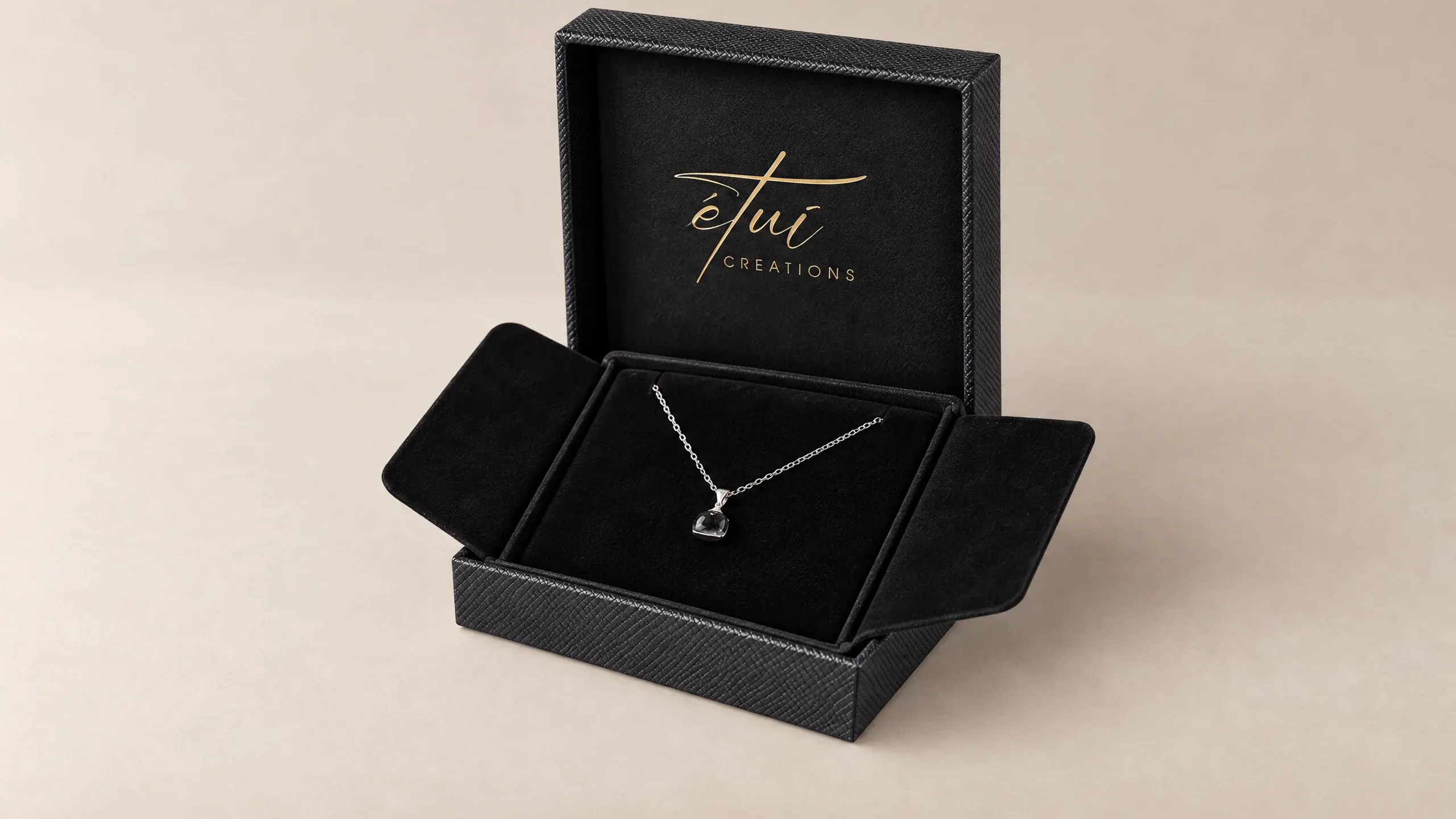 Open box in Black: lid behind the base, necklace in the insert