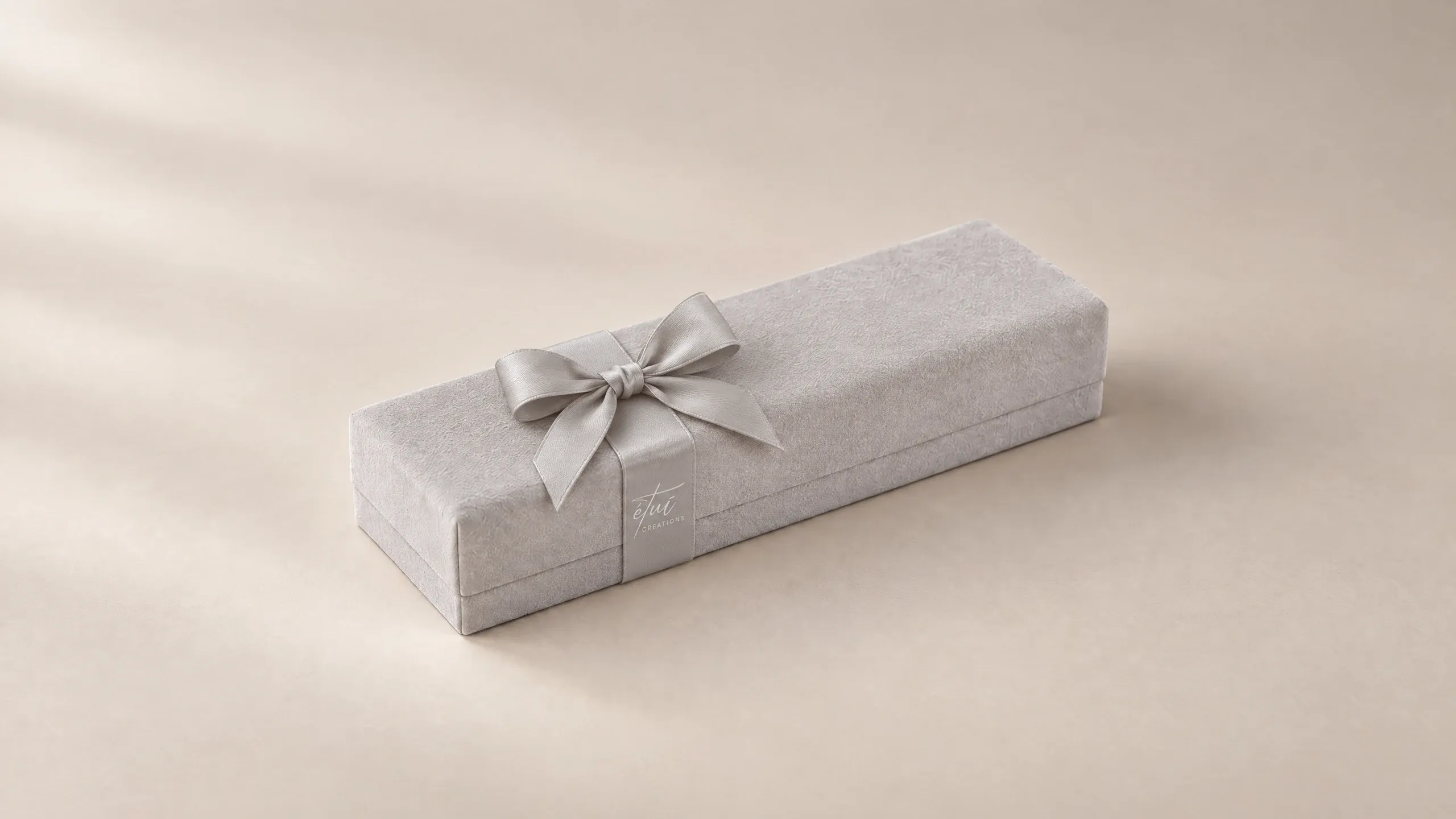 Box in Grey with a satin ribbon, the logo on the band