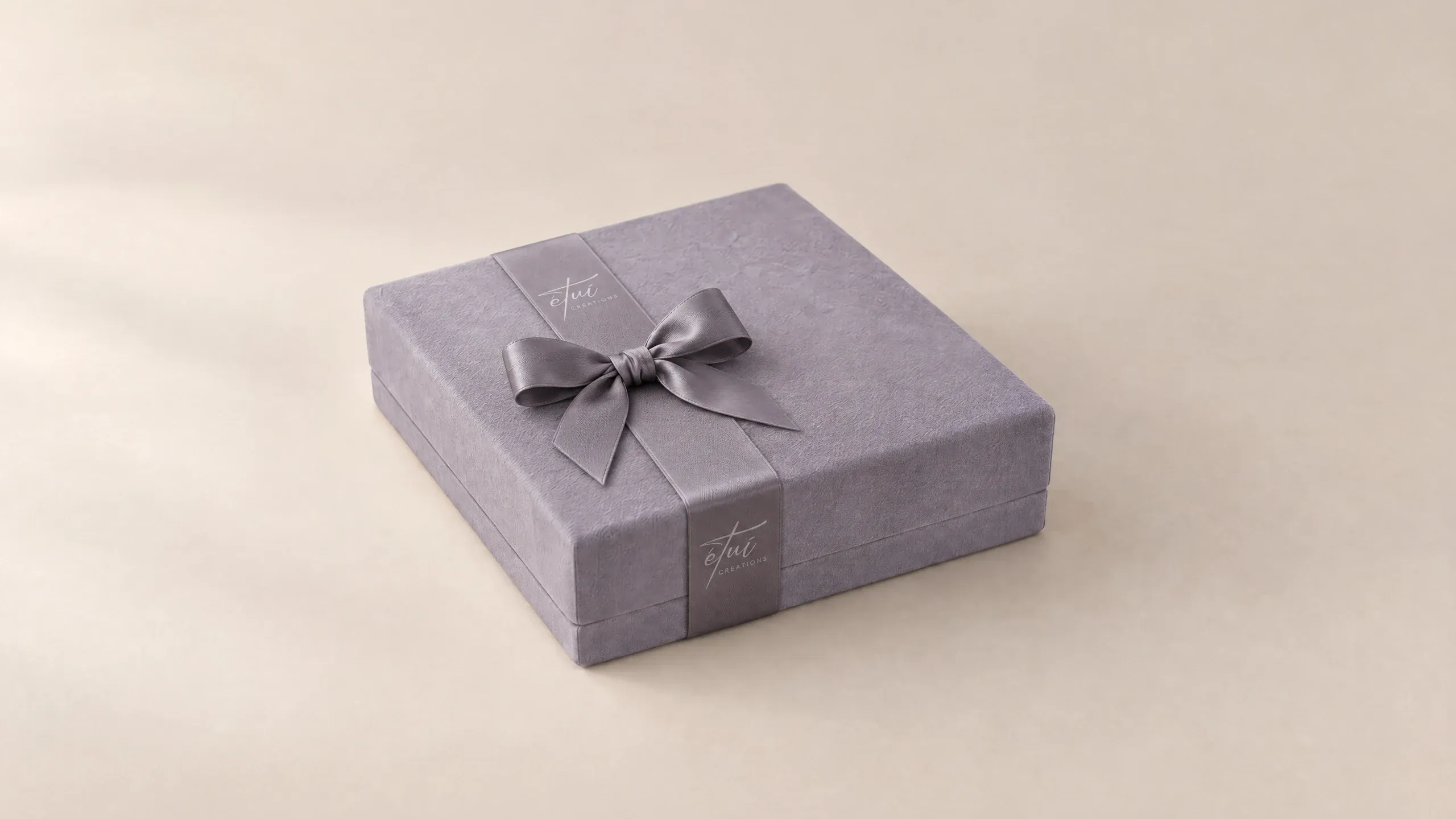 Box in Anthracite with a satin ribbon, the logo on the band