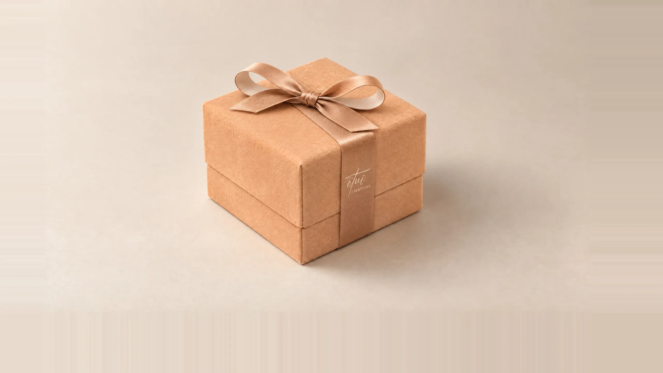 Box in Caramel / Cream with a satin ribbon, the logo on the band