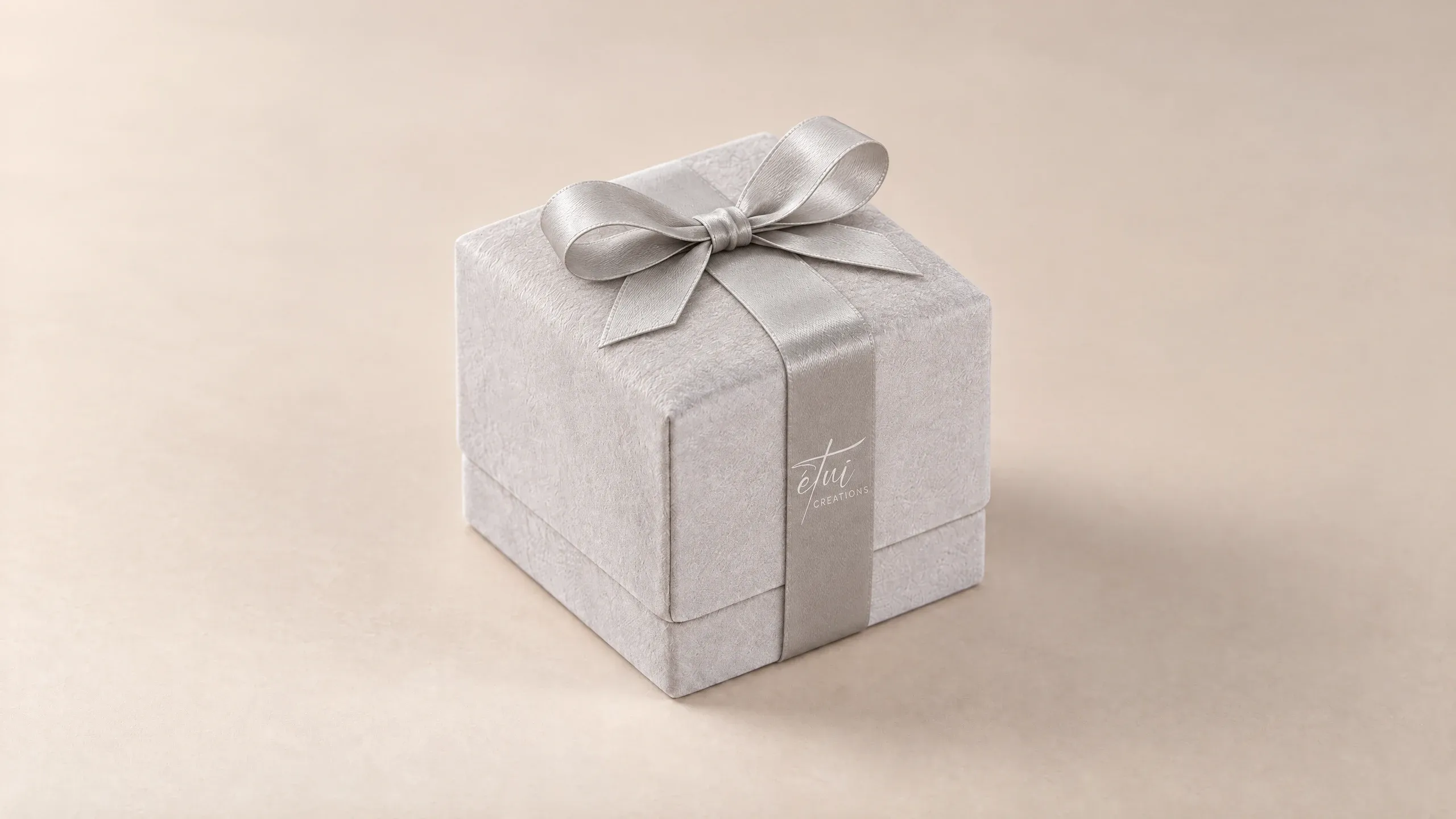 Box in Grey with a satin ribbon, the logo on the band