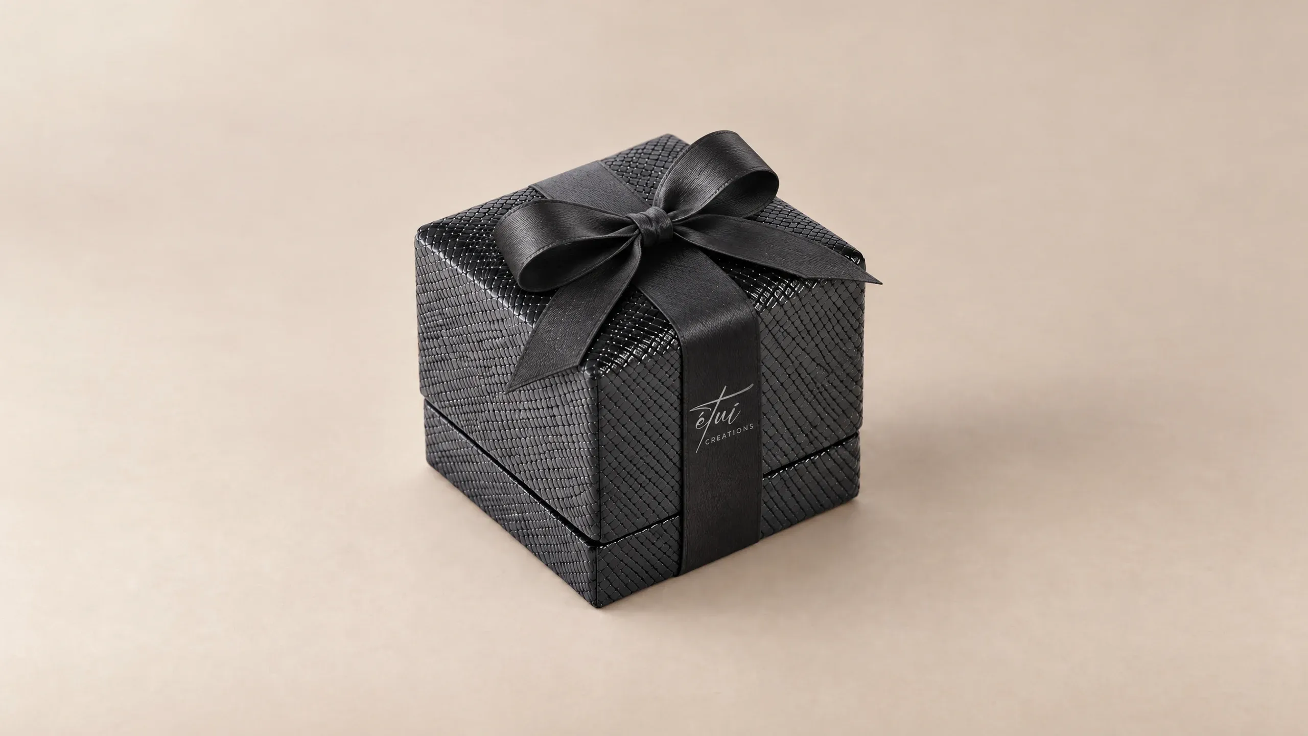 Box in Black with a satin ribbon, the logo on the band