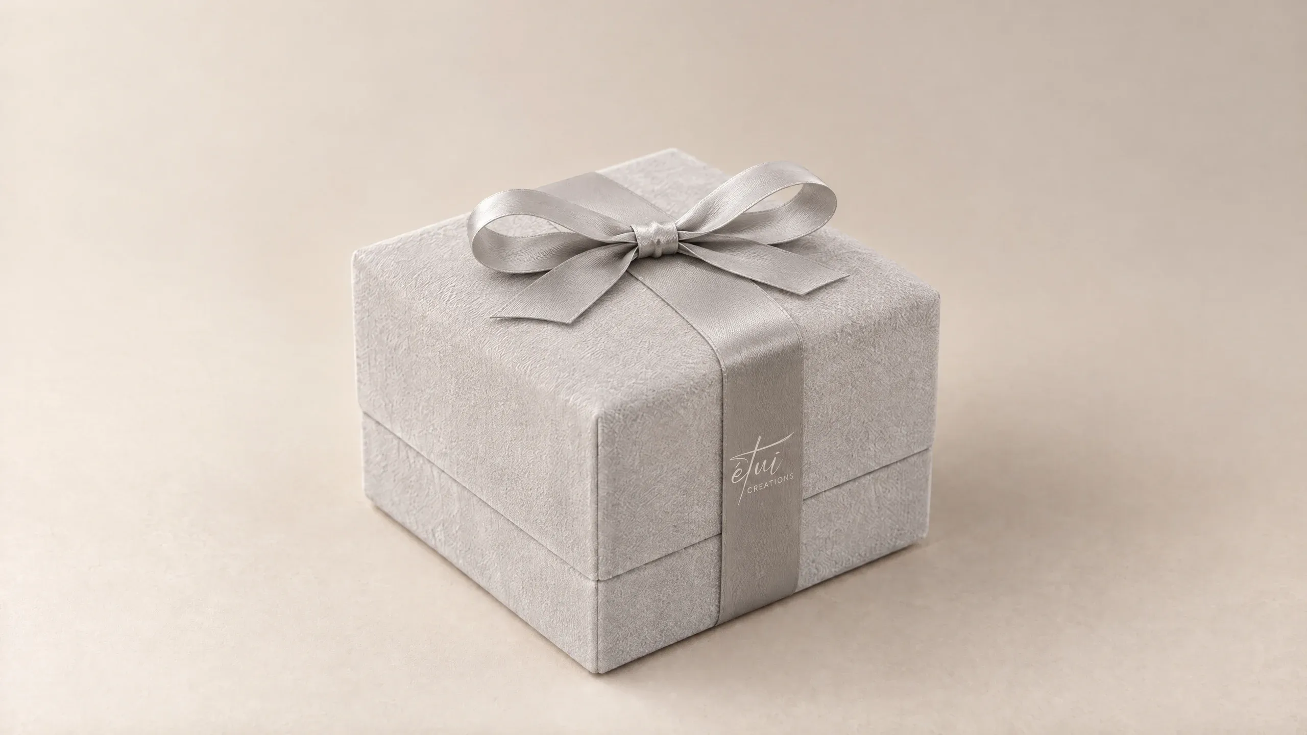 Box in Grey with a satin ribbon, the logo on the band
