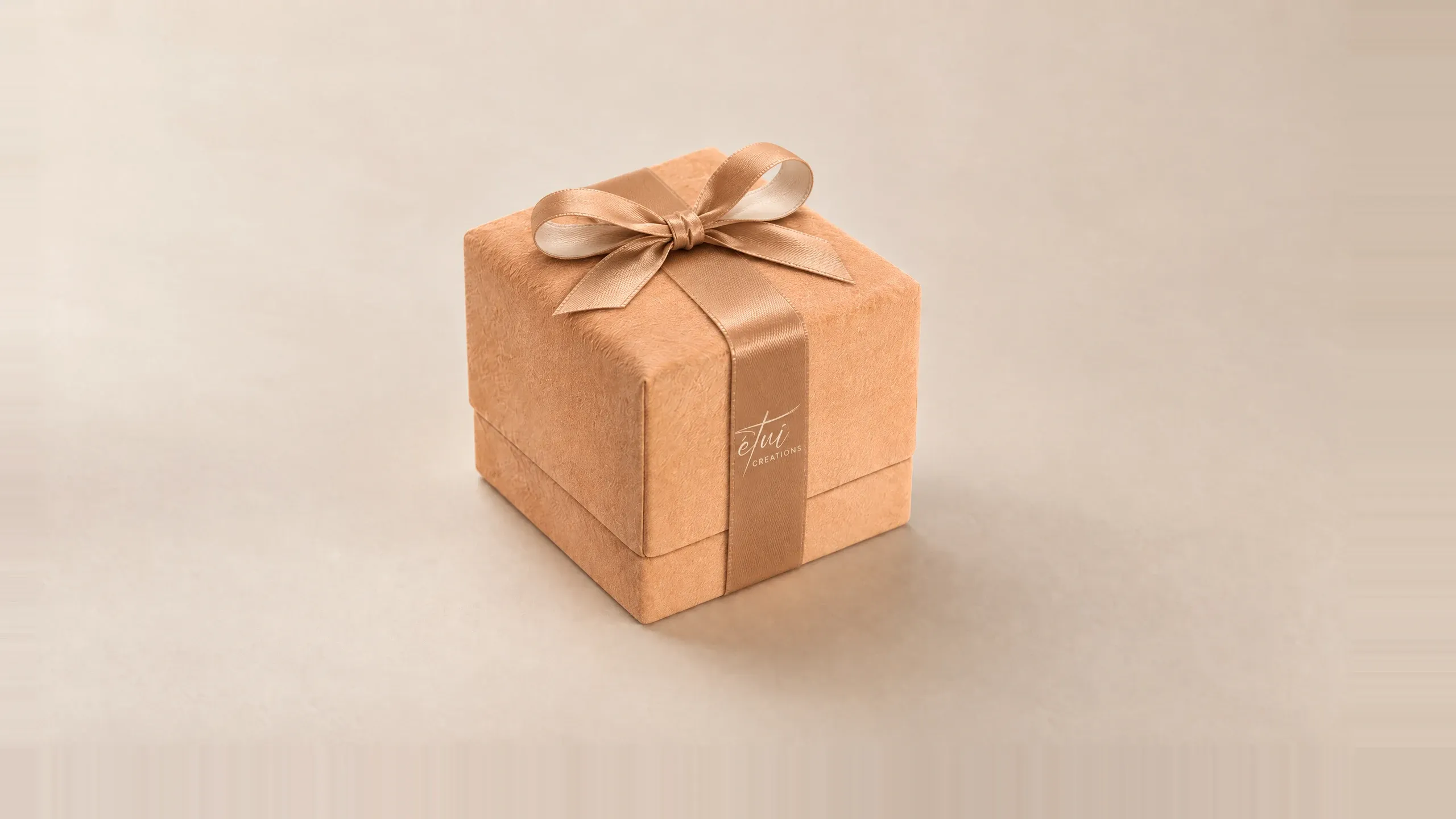 Box in Caramel / Cream with a satin ribbon, the logo on the band