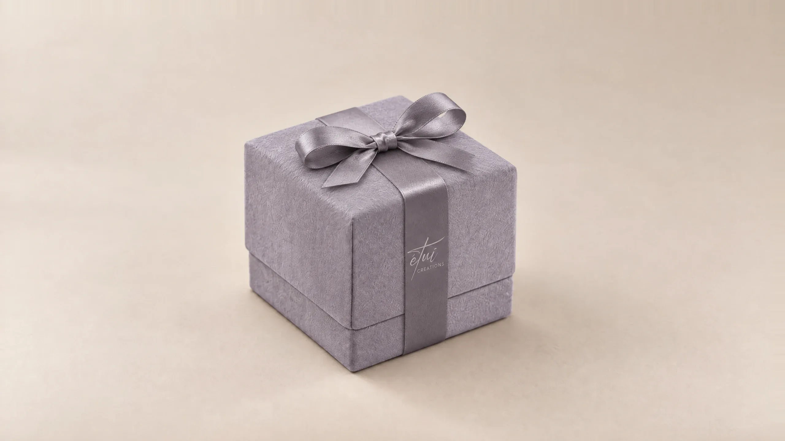 Box in Anthracite with a satin ribbon, the logo on the band