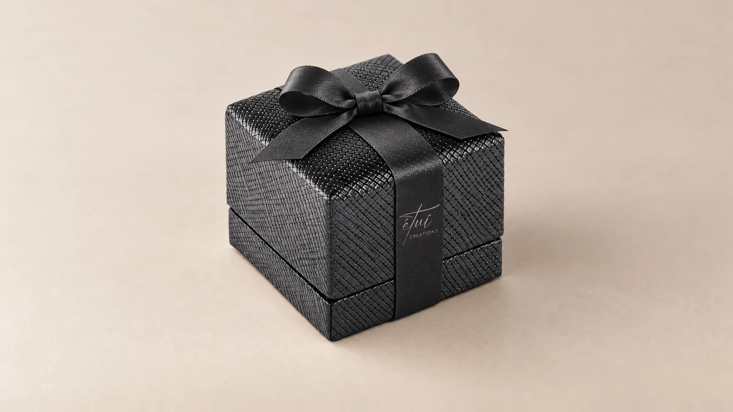 Box in Black with a satin ribbon, the logo on the band