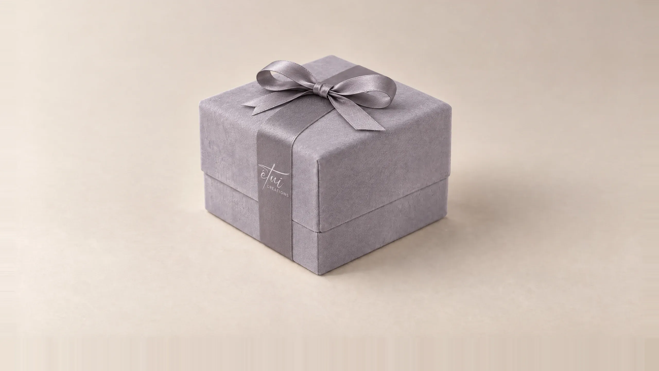 Box in Anthracite with a satin ribbon, the logo on the band