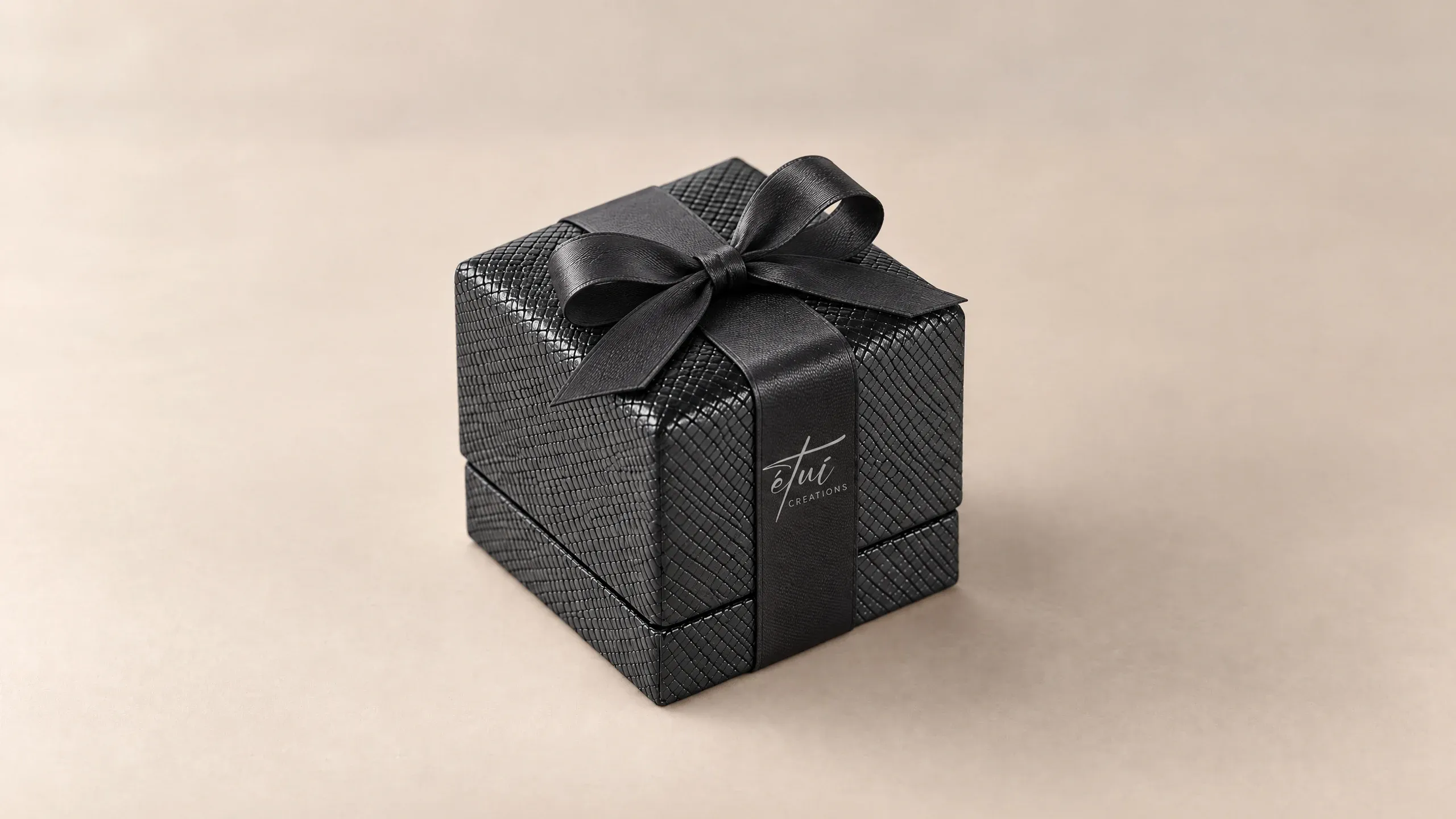 Box in Black with a satin ribbon, the logo on the band