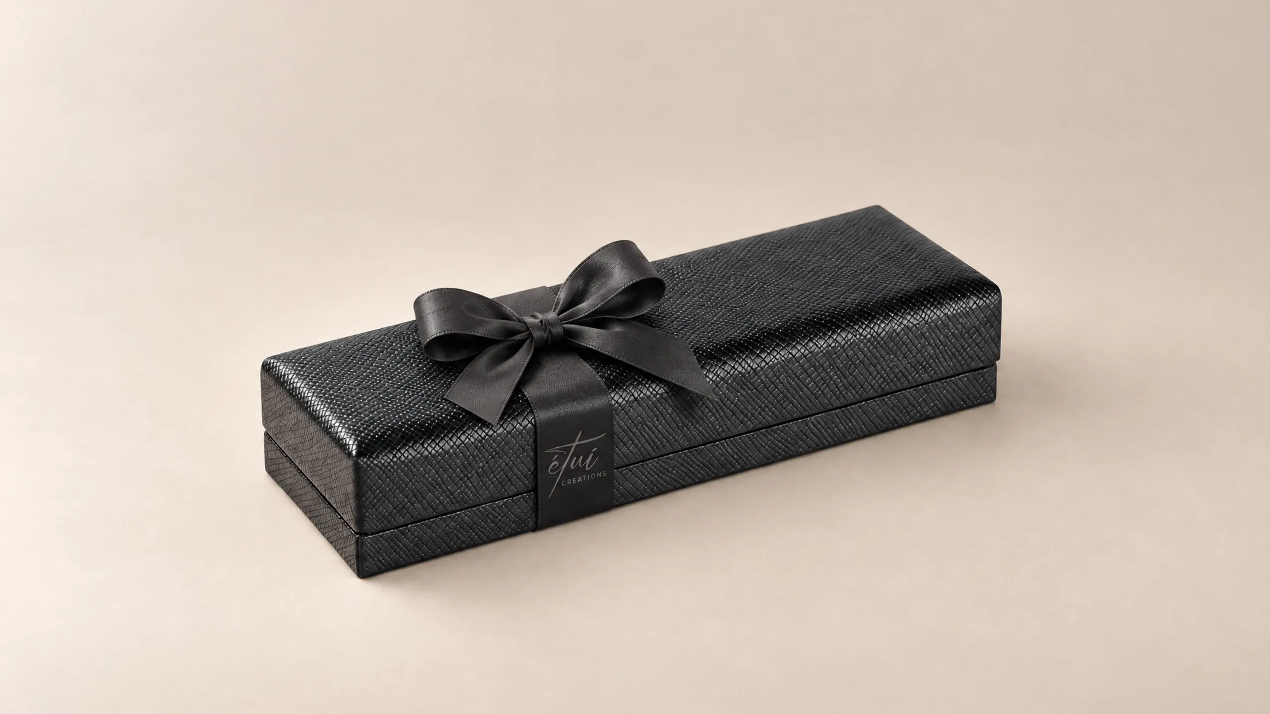 Box in Black with a satin ribbon, the logo on the band