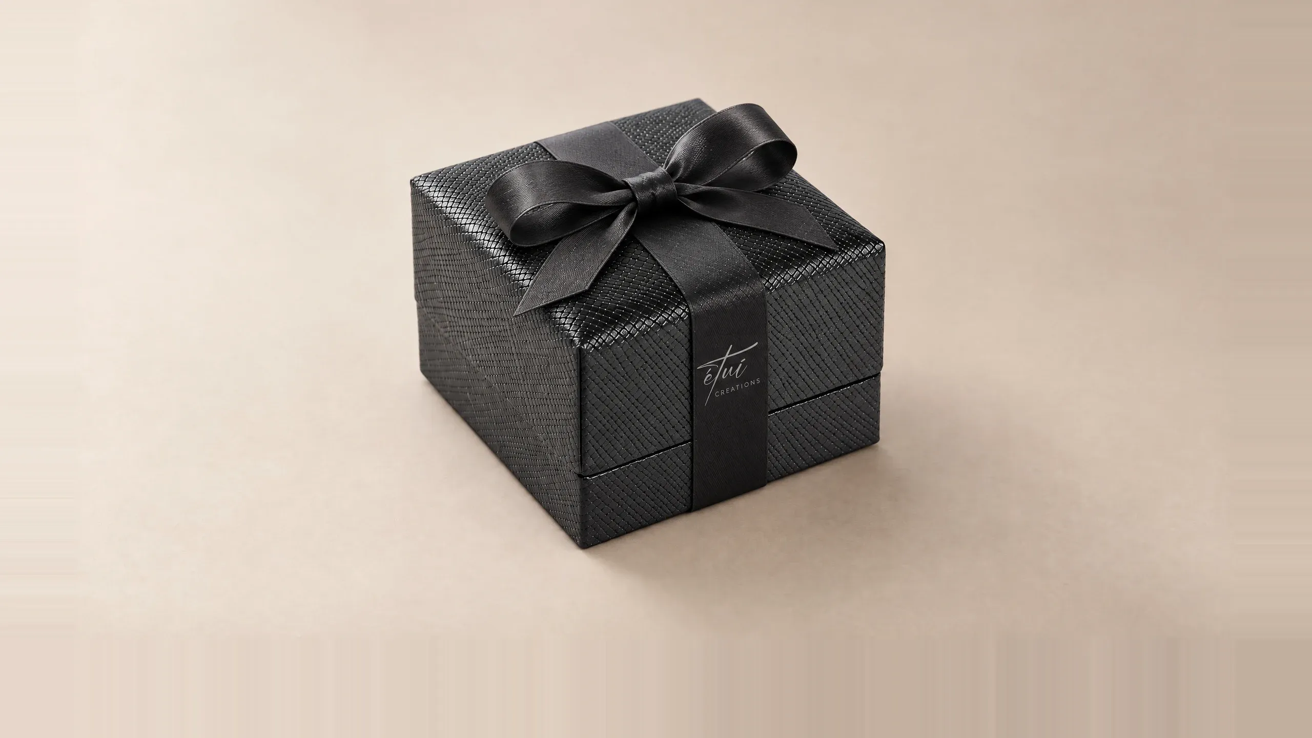 Box in Black with a satin ribbon, the logo on the band